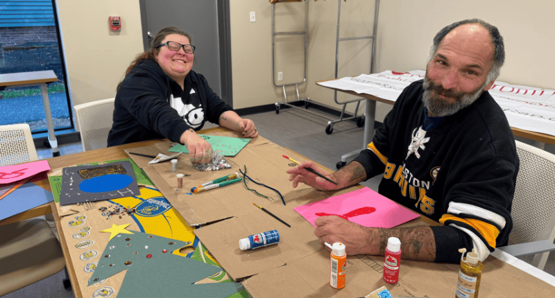 Two people sitting at a table with some paper